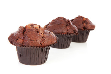 Three chocolate cupcakes over white background