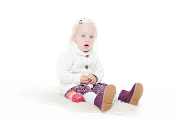 little girl in a knitted jacket on a white background