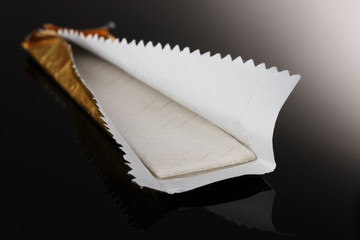 Chewing gum on the wrapping foil on gray background