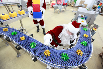 santa claus at christmas ornament production line in factory