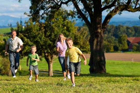 Familie im Freien läuft auf einer Wiese