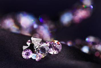 Diamond (small purple jewel) stones heap over black silk cloth b