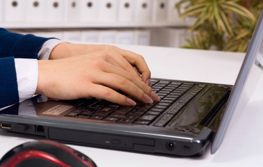 Person Typing on a modern laptop in an office