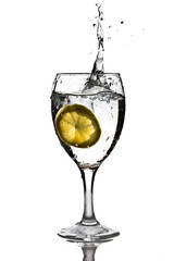 Slice of lemon dropped into the glass of water with splash