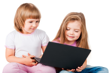 two smiling girls looking at laptop