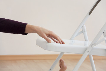 Frau im Yoga Unterricht mit Stuhl