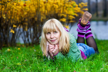 Blond woman in gaiters lying on the grass