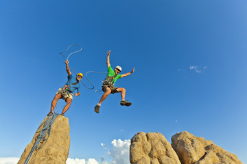 Rock climbing team reaching the summit.