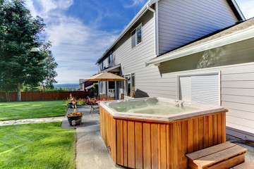 Back yard with house and lrage tub