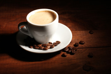 cup with coffee and coffee beans on  wooden table