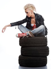 Punk girl sitting on tires.