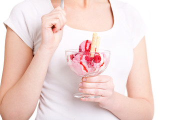 Frau hält Eisbecher vor Oberkörper