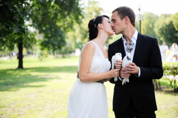 Bride and groom kissing each other outdoors