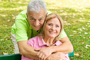 happy elderly man embracing mature woman