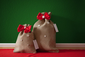 Santa's bags with red bows and stars, green wall, red carpet