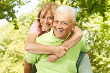 happy senior man giving piggyback ride