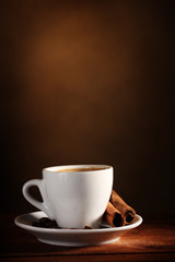 cup with coffee, cinnamon and coffee beans