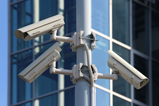 three cctv security cameras on the street pylon