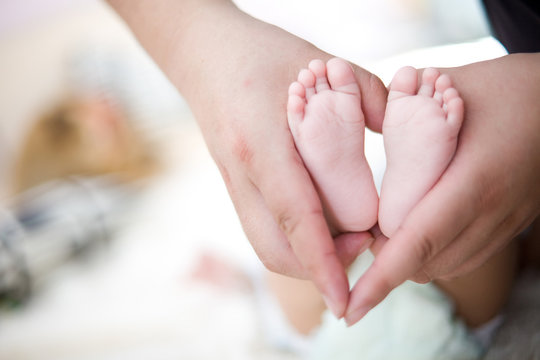 hold baby's foot as love heart shape
