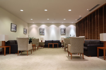 leather sofas, armchairs and tables in light, empty office