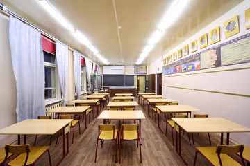 Back view of tables and chairs in empty physics school class