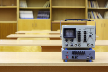 Old educational oscilloscope on desk in physics school class