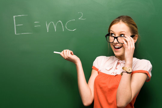 Student standing by chalkboard with e=mc2