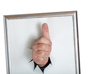 Hand mit Daumen nach oben durchbricht das Papier