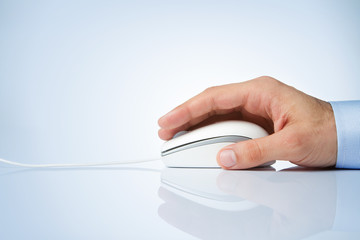 Male hand holding computer mouse with copy space