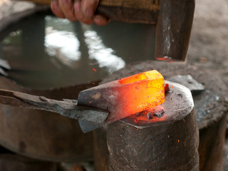 Blacksmith forging an ax