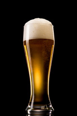 Beer into glass on a black
