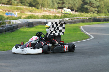 Go kart race winner with chequered flag