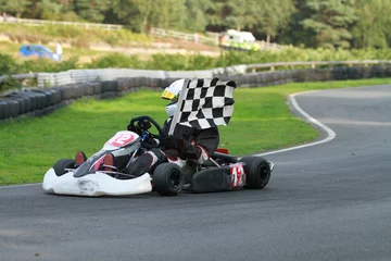 Fototapeten Go kart race winner with chequered flag © Nicky Rhodes