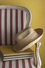 Sombrero con libros en una silla