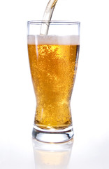 Light beer poured into glass on white background