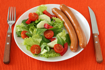 sausages with salad on white plate