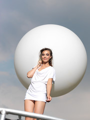Naklejka premium young woman on trampoline with white balloon