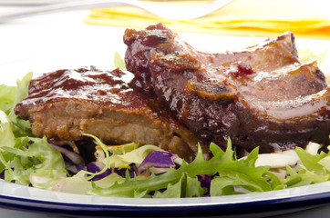 gegrillte Spareribs auf einem Teller mit frischem Salat