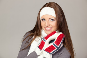 Fototapeta premium Closeup of a girl in warm clothing, over grey background