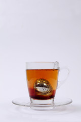 Tee-Ei in Tasse aus Glas auf weißem Untergrund