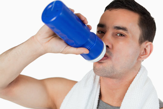 Close up of young man drinking water after workout