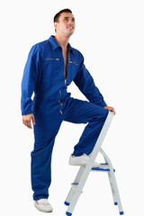 Portrait of a mechanic climbing on a stool