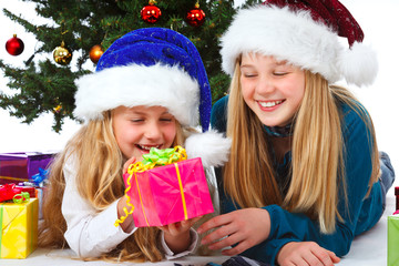 Fototapeta na wymiar two girl with santa hat and gift smiling