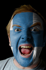 Face of crazy angry man painted in colors of finland flag
