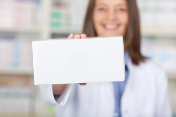 lächelnde apothekerin zeigt weiße verpackung