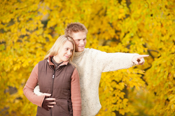 Autumn romantic couple smiling together in park