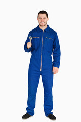 Fototapeta premium Smiling young mechanic in boiler suit with a wrench