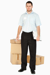 Young post employee with parcels and clipboard