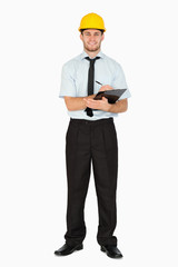 Smiling young foreman taking notes on his clipboard