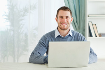 Smiling young businessman working in his homeoffice